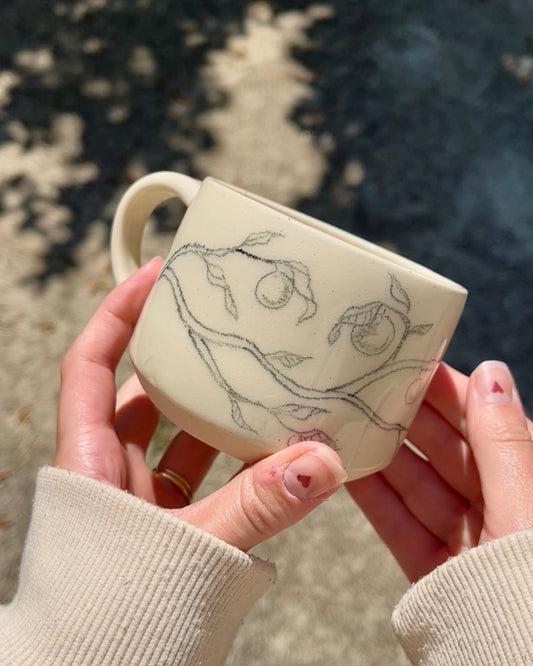 ceramic mug with hand drawn fruit branch design 